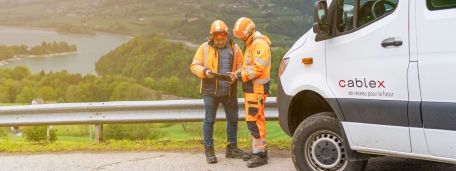 Projektbesprechung zwischen zwei cablex Mitarbeitenden in wunderschöner Natur.